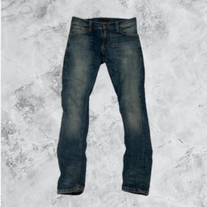 Nudie Jeans - Snygga blå Nudie jeans i storlek W26/30  Klassisk passform med fickor fram och bak.  Skick 9/10 Perfekta för både vardag och stilrena outfits! Skriv om du har några funderingar…