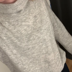 Grå stickad polotröja från Jacqueline de Yong - Mysig grå stickad polotröja från Jacqueline de Yong. Perfekt för kyliga dagar med sin höga krage och långa ärmar. Enkel och stilren design som passar till det mesta. 🧶