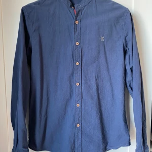 Snygg skjorta  - Riktigt snygg skjorta utan krage. Den är i ett skönt material. Väldigt bra skick, använd fåtal gånger. I strl S. Passar perfekt nu till sommaren. Hör av dig vid någon fundering👑