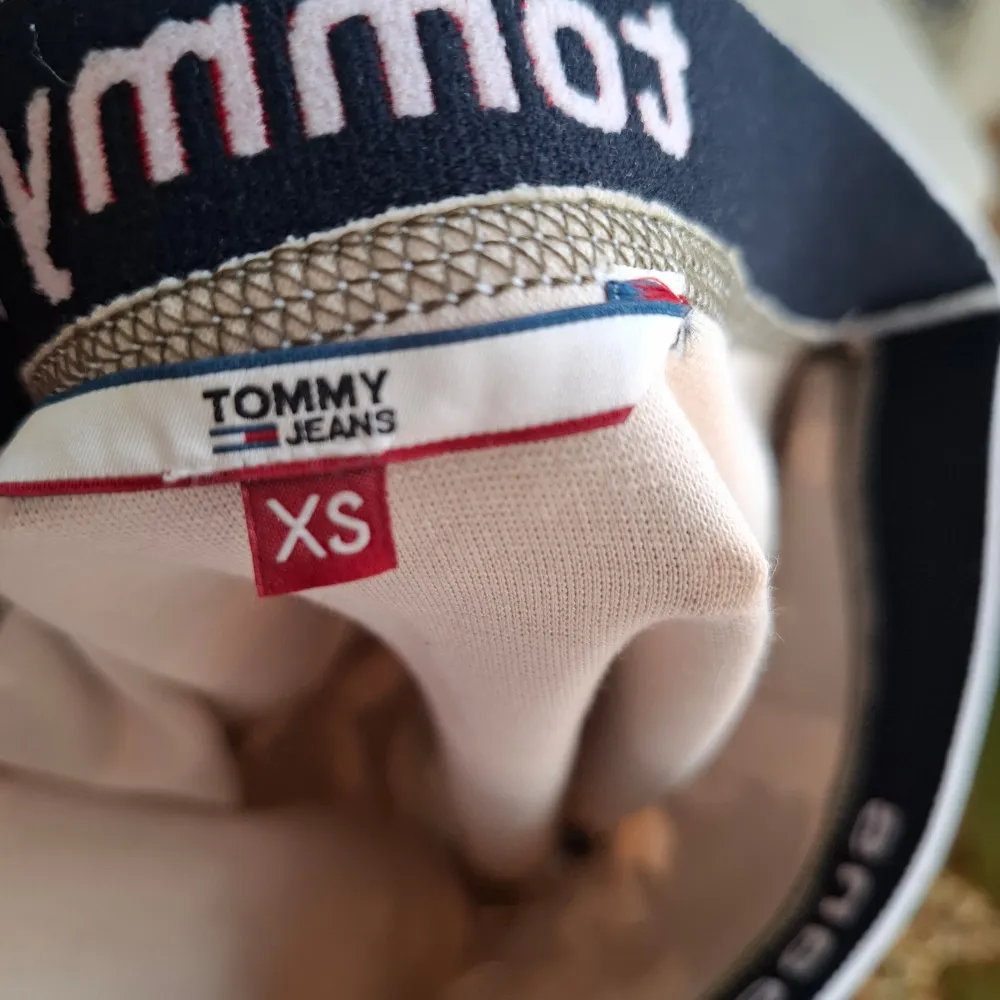 Snygg camo-mönstrad kjol från Tommy Jeans i storlek XS. Kjolen har en elastisk midja med märkets logga i rött och blått. Perfekt för en cool och avslappnad stil.. Hameet.