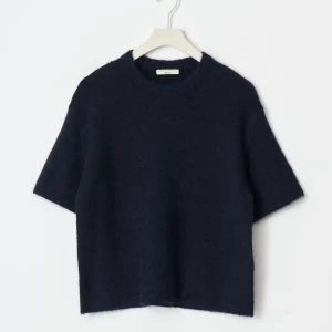 Mörkblå stickad tröja från Cos - Säljer en stilren mörkblå stickad tröja från Gina tricot. Tröjan har en enkel design med korta ärmar och rund halsringning. 
