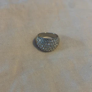 Glittrig silverring - Säljer en glittrig silverring med många små stenar som täcker ovansidan. Den e dock lite stor på mig, men ja vet inte riktigt vilken storlek den är 