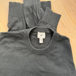 Kashmirtröja från H&M - Säljer en stilren mörkgrå tröja från H&M. Tröjan är tillverkad i en mjuk blandning av bomull och kashmir, vilket gör den både bekväm och lyxig. Perfekt för kyligare dagar. Storlek M! Väldigt skön och nice!