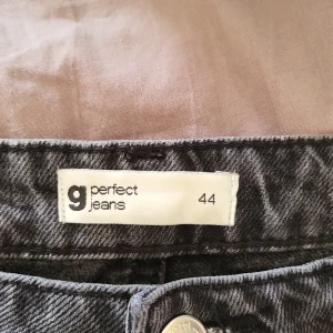 Svarta jeans från Perfect Jeans - Snygga svarta jeans från Perfect Jeans med klassisk femficksdesign. De har en rak passform och är perfekta för en stilren look. Jeansen har en knapp och dragkedja framtill.