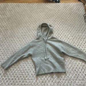 Grå hoodie från Zara - Säljer en stilren grå hoodie från Zara. Den har en bekväm passform med långa ärmar och en praktisk huva med dragsko. Perfekt för en avslappnad look.