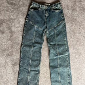 Blå jeans från NA-KD - Snygga blå jeans från NA-KD med unik sömdesign som ger en cool look. De har en klassisk femficksmodell och knappgylf. Perfekta för en avslappnad stil. Använda 1 gång