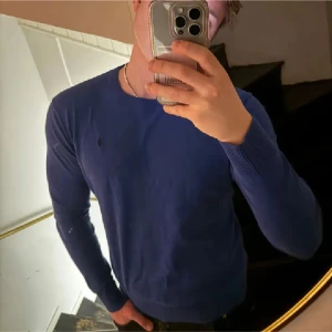 Blå tröja med rund hals - Snygg blå tröja med rund hals och långa ärmar. Perfekt för en stilren look. Passar bra till både jeans och chinos.