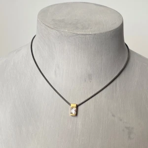 Halsband med guldpläterad hänge och svart kedja - Elegant silverhalsband med en svart kedja och ett guldpläterat hänge med en klar sten.  Kedjan har en säker låsning och är  märkt med 925.