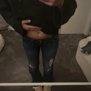 Only jeans bootcut lowwaist - Snygga mörkblå jeans från ONLY med slitna detaljer och bootcut-stil. Perfekta för en avslappnad look. De har en låg midja och är tillverkade i jeansmaterial.