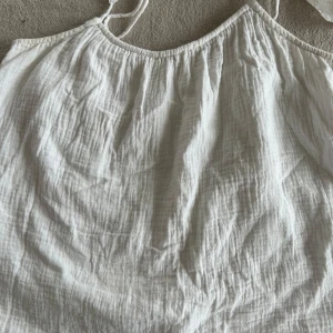 Vit linnetopp från H&M - Säljer en luftig och somrig vit linnetopp från H&M. Toppen har tunna axelband och en avslappnad passform, perfekt för varma dagar. Passar bra till både jeans och kjol. 🌞