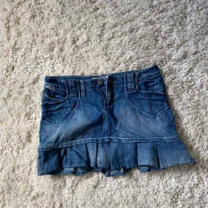 Jättesöt lågmidjad jeanskjol med volang! - Säljer en jättesnygg jeanskjol med volanger! Perfekt till sommaren och ger rn stilren outfit! Säljer då den är för stor för mig! Midjemått-38cm Längden-31cm