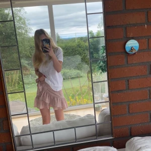 Rosa omlottkjol med volang - Söt rosa omlottkjol med volangdetaljer och knytning i sidan. Kjolen har ett diskret leopardmönster som ger en trendig touch. Perfekt för varma sommardagar. Har använt mycket men inget tydligt tecken förutom att lappen på insidan är utsliten. Köpt på shein 