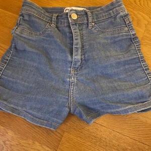 Blå jeansshorts från Cropp - Säljer ett par klassiska blå jeansshorts från Cropp. De har en hög midja och femficksdesign med knapp och dragkedja framtill. Perfekta för sommardagar! 🌞