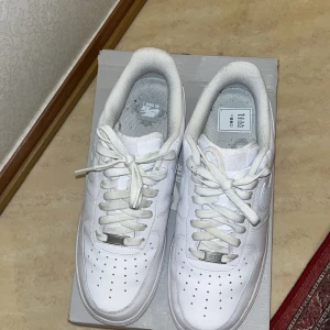 Vita Nike Air Force 1 sneakers - Säljer ett par klassiska vita Nike Air Force 1 sneakers. Perfekta för en casual look. Skorna är i storlek 45 och har används 1 gång. Nästan intill nytt skick. Original pris 1500kr. Låda följer med. Snörena behöver eventuellt tvättas eller förnyas. Ingen crease på skorna och dom är fortfarande lika vita som ett par nya!