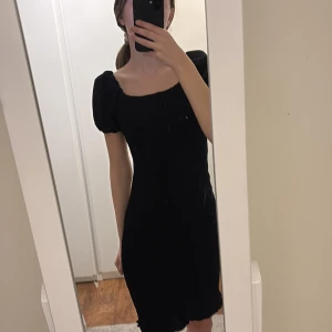 Svart klänning med puffärmar - Snygg svart klänning med puffärmar och en tight passform. Klänningen har en texturerad yta som ger en unik look. Perfekt för en stilren och elegant outfit. Väldigt fin och skön. Storlek S ifrån Gina tricot. 🖤
