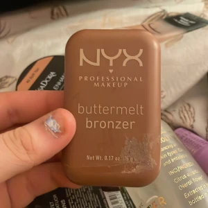 Buttermelt Bronzer från NYX - Säljer en NYX Professional Makeup Buttermelt Bronzer i nyansen 'Butta Off'. Denna bronzer har en krämig konsistens och kommer i en kompakt brun förpackning. Perfekt för att ge ansiktet en solkysst glöd. Den är bökigt pigmenterad och väldigt fin så den kommer hålla länge 