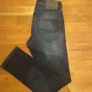 Jack&Jones Glenn Jeans - Snygga mörkgrå jeans från Jack & Jones med slitna detaljer på framsidan. Modellen glenn som är sjukt populär. De har en klassisk femficksdesign och en bekväm passform. Perfekta för en avslappnad stil. Skick:10/10, Storlek: Waist:28, Length:30