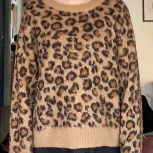 Leopardmönstrad stickad tröja - Säljer en leopardmönstrad stickad tröja i beige och bruna toner. Tröjan har långa ärmar och en rund halsringning. Från h&m 