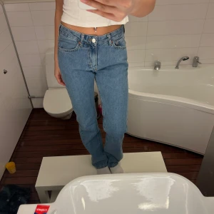 Blå jeans med hög midja - Säljer ett par klassiska blå jeans med hög midja. De har en rak passform och fem fickor. Perfekta för en avslappnad stil.