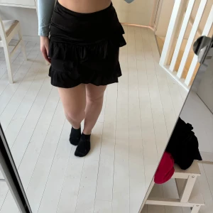 Svart volangkjol - Snygg svart kortkjol med volanger. 