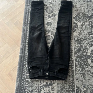 Svarta jeans från Replay - Snygga svarta jeans från Replay med klassisk femficksdesign och knappgylf. Jeansen har en stilren look och passar perfekt för en trendig vardagsstil. De kostar i ny pris 1900 och har inte använt de så mycket. De är 152cm. Gick inte att skriva vilken storlek 