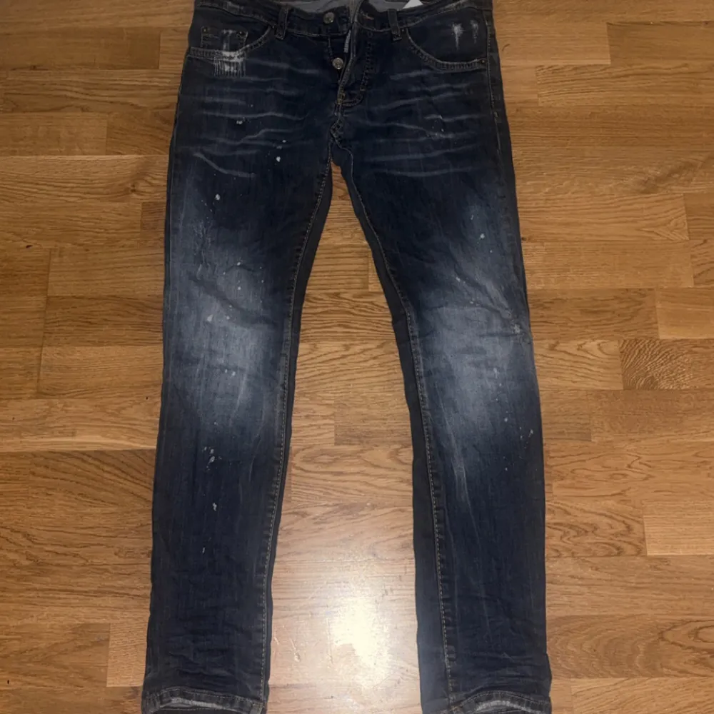 Snygga mörkblå jeans från Dsquared2 med en cool tvättad look och slitna detaljer. De har en knappgylf och klassisk femficksdesign. Perfekta för en avslappnad stil.. Farkut & Housut.