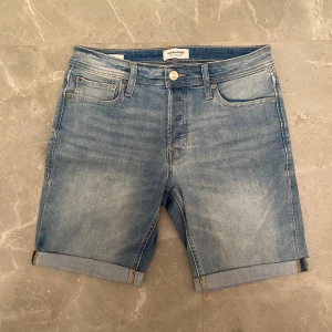 Jeansshorts Jack & Jones  - Jeansshorts från Jack&Jones i modellen regular.  Midjemått: 39 cm. Ytterben: 45 cm. Innerben: 21 cm. Gren till knapp: 25 cm. Knappt använda!!🙌