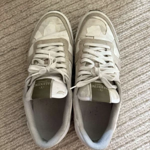 Valentino Rockrunner - Snygga Valentino Rockrunner sneakers i beige och vitt med coolt camouflagemönster. Skorna har detaljer i mocka och skinn, klassisk snörning och ikoniska nitar vid hälen. Perfekta för dig som vill ha en lyxig och trendig look. Dom är köpte ifrån TheRealReal, finnskvitto osv. Har ingen box! Priset kan diskutera vid snabbaffär!🍀