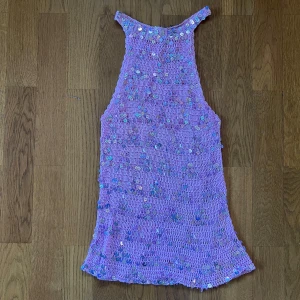 Rosa paljettopp i virkat material - Superfin rosa topp i virkat material med massor av glittriga paljetter över hela toppen. Perfekt för dig som vill sticka ut och glänsa lite extra. Någon liten fläck, vänligen se sista bilden. Passar XS-L.