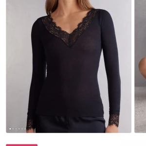 Svart långärmad topp med spetsdetaljer - Supersnygg svart långärmad topp med djup v-ringning och spetsdetaljer både vid halsringningen och ärmsluten. Tunn och mjuk, perfekt att styla med jeans eller kjol. Ändast använd 3 gånger och säljs för den ej kommer till användning tyvärr. Prisk kan diskuteras😊💕