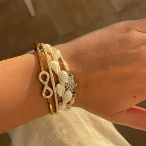 Infinity armband - Guldarmband med oändligthetstecknet med silvriga stenar på. Köpt på Gran Canaria!