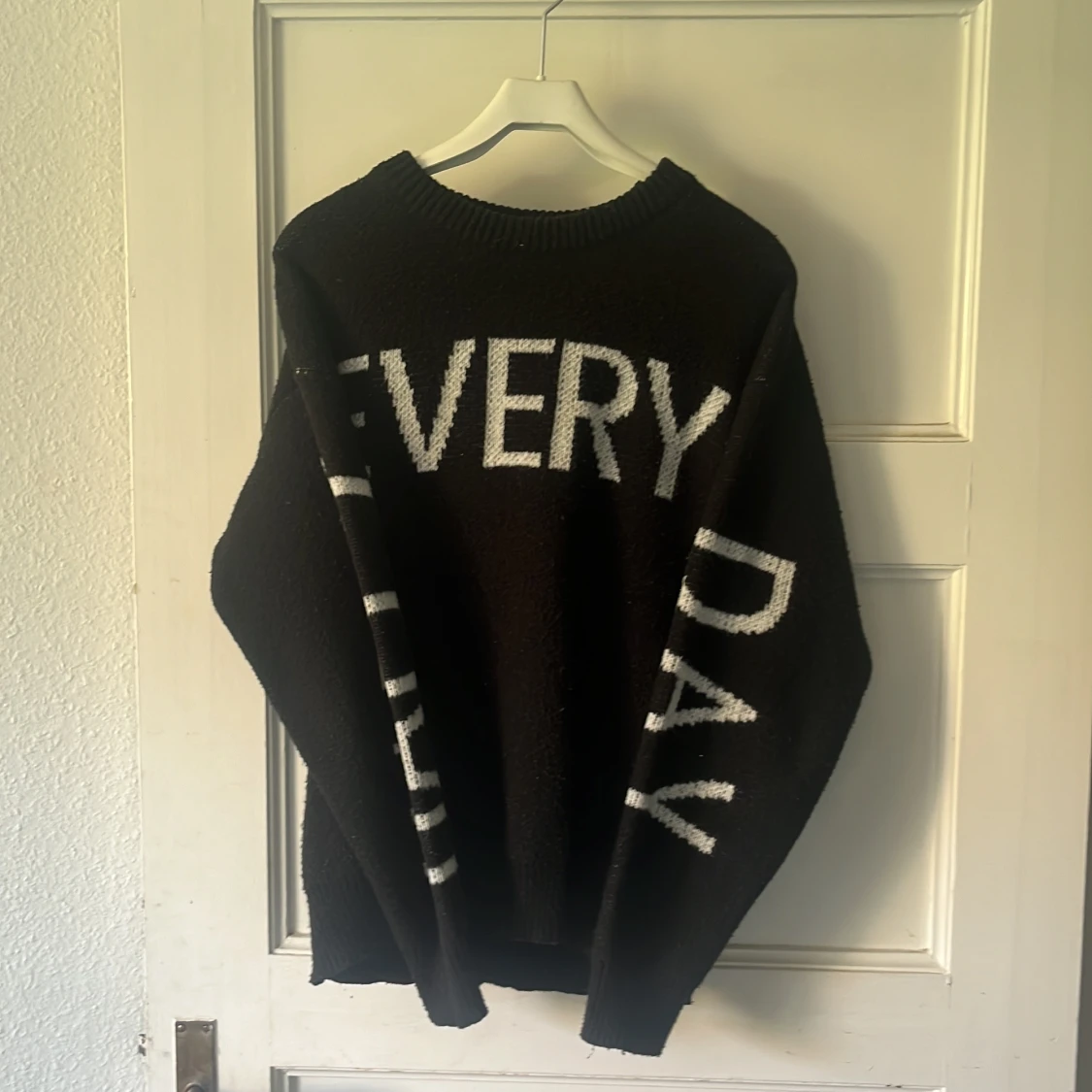 Svart stickad tröja med text - 1