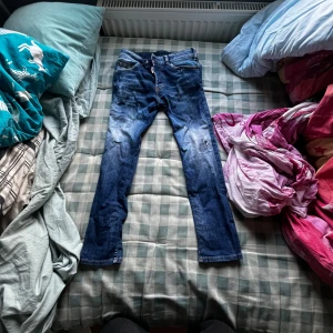 Hej jag säljer ett par blå dsquared, jag säljer dom för att dom inte passar mig längre. - Det är inget fel på byxorna dom är i ganska bra skick dom har 2 hål där framme men de är ett lager under hålen så det inte går rakt igenom. 158-162 cm
