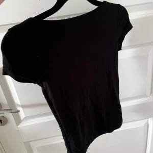 Svart topp med djup rygg - En svart, tight topp med korta ärmar och djup i ryggen. Toppen är från Gina tricot 🥰