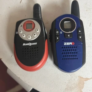 Två stycken olika walkie talkies. Familjen påstår att dem är hemsökta så om det finns någon djärv och modig människa som klarar av knäppande ljud passar detta perfekt för dig. Speciellt om du är ute och gömmer dig med en vän på övergivna platser. - Bilderna visar två walkie-talkies av märkena Marquant och Zero. De är kompakta, har tydliga knappar och display, perfekta för äventyr, spel eller kommunikation på utflykter. Passar dig som gillar teknik och vill hålla kontakten med vänner på ett roligt sätt. Samt utmana din djärvhet med lite sunda ljud.