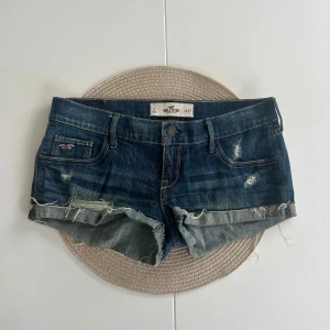 Lågmidjade jeansshorts Hollister - Ett par Hollister jeansshorts i storlek W27 (S). Rakt över midjemått: 38cm. Längd: 18cm. Gren: 17cm. D10