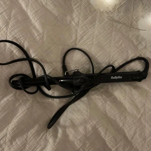 Svart locktång från BaByliss 35kr - Säljer en svart locktång från BaByliss med smal cylinder och klämma. Perfekt skick, 100kr