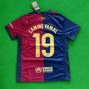 FC Barcelona Lamine Yamal tröja Nike - Snygg FC Barcelona fotbollströja med Lamine Yamal och nummer 19 på ryggen. Tröjan är kortärmad och har klassiska blå och röda fält, gul Nike-logga och klubbmärke framtill. Tillverkad i lätt och ventilerande polyester, perfekt för match eller träning.