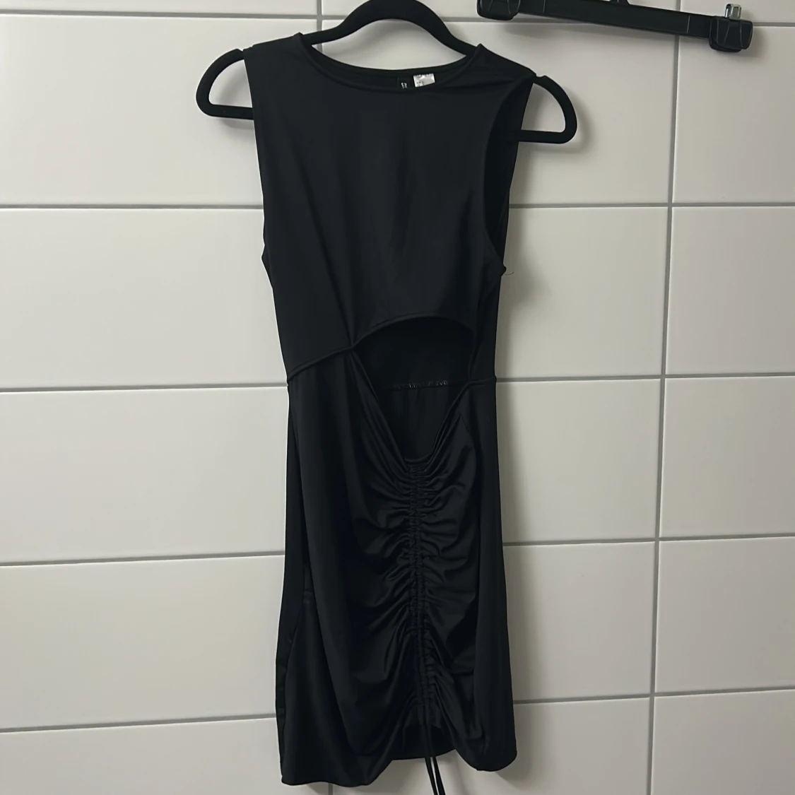 Svart kort klänning med snörning och öppen vid magen