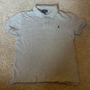Grå pikétröja från Polo Ralph Lauren - 9/10 skick riktigt fett. Oanvänd Ralph Lauren piké. Sjukt snygg pike! Nytt pris 1000kr+ Materialet är mjuk bomull som känns skönt mot huden.