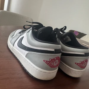 Jordan 1 Low ”Light Smoke Grey” - Nike Air Jordan 1 Low Light Smoke grey i storlek 44.  Nypris: 3200kr  Använts flitigt, dem är lite creasade vilket skorna blir med tiden samt lite slitna ovanför skons tunga. Inget som syns om man har byxorna som täcker för.