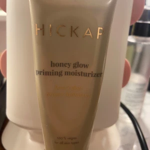 Hickap Honey Glow Primer - Honey glow priming moisturizer från Hickap. Ger en fräsch glow och fungerar både som primer och återfuktande kräm. Kommer i en beige tub med guldiga detaljer. 100% vegansk och passar alla hudtyper. Lite använd 