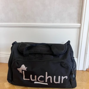 Cheerleading väska - Säljer min cheerleading bag då den inte kommer till användning längre. Väskan är i bra skick och rymlig storlek. Bredd-25cm, höjd-30cm, längd-50cm