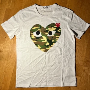 CDG T-shirt - Fet t-shirt från Comme des Garcons med camohjärta😍. Snygg och går att matcha med allt💯. I princip nyskick. Hör av dig om du har funderingar!