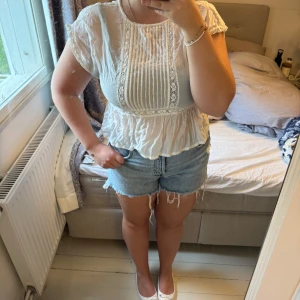 🤍💞Vit blus med spetsdetaljer från Oysho - Säljer en söt vit blus från Oysho med spetsdetaljer och fina veck framtill. Blusen har korta ärmar och en lätt, luftig passform. Perfekt till sommaren och enkel att matcha med jeans eller kjol💓🤍