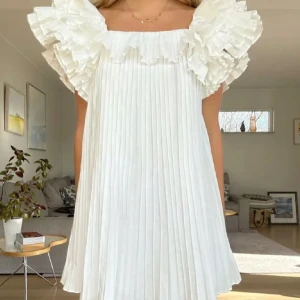 Intressekoll!!  - Intressekoll på denna superfina vita klänningen med plisserat tyg och stora volangdetaljer vid axlarna. Väldigt populär och eftertraktad! Perfekt till student och skolavslutning. Kontakta mig vid intresse! 