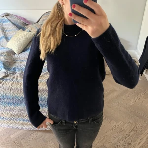 Mörkblå stickad tröja - Mörkblå stickad tröja med lång ärm och rund halsringning från Zara. Köpt nu iår och är i bra skick. Från början storlek M men har krympt lite så skulle snarare säga S/XS. Orginalpris 1000kr. Gjord i cachmere. 