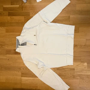 Vit halvzip från Polo Ralph Lauren - Säljer en stilren vit halvzip-tröja från Polo Ralph Lauren. Tröjan har lång ärm, hög krage och dragkedja framtill. Broderad logga på bröstet och mjukt grått innerfoder i kragen. Perfekt för en clean och klassisk look. Nypris:2295kr säljer nu för 1395kr.  Är oanvänd sälj då den var förstor 
