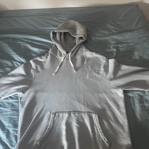 Grå hoodie från Polo Ralph Lauren - Säljer en klassisk grå hoodie från Polo Ralph Lauren med broderad logga                                            Trojan har ett litet lagat hål vid fickan som inte syns.  Priset kan diskuteras och byter gärna               Skickar snabbt 