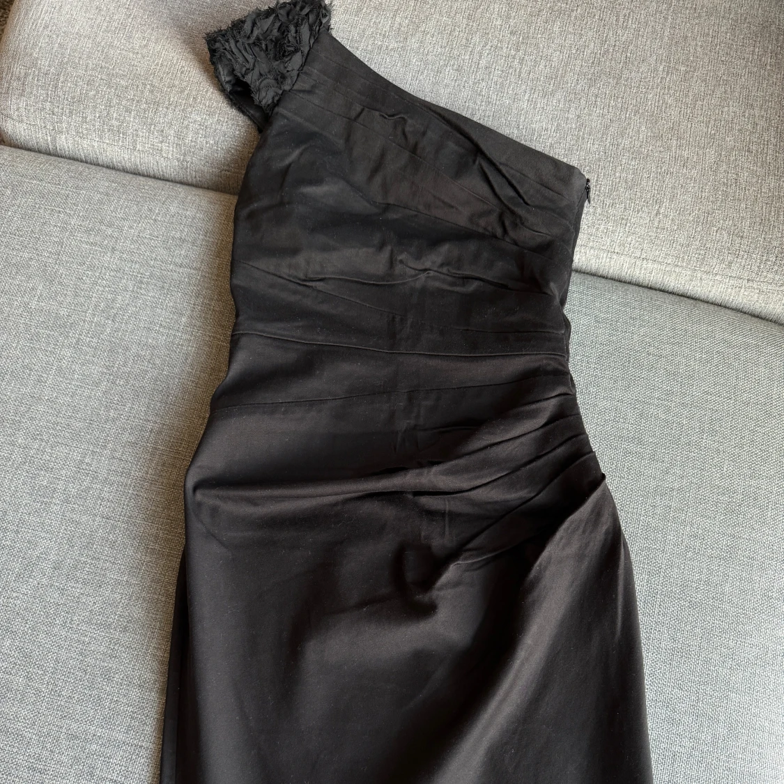 Svart oneshoulder klänning med volangdetalj